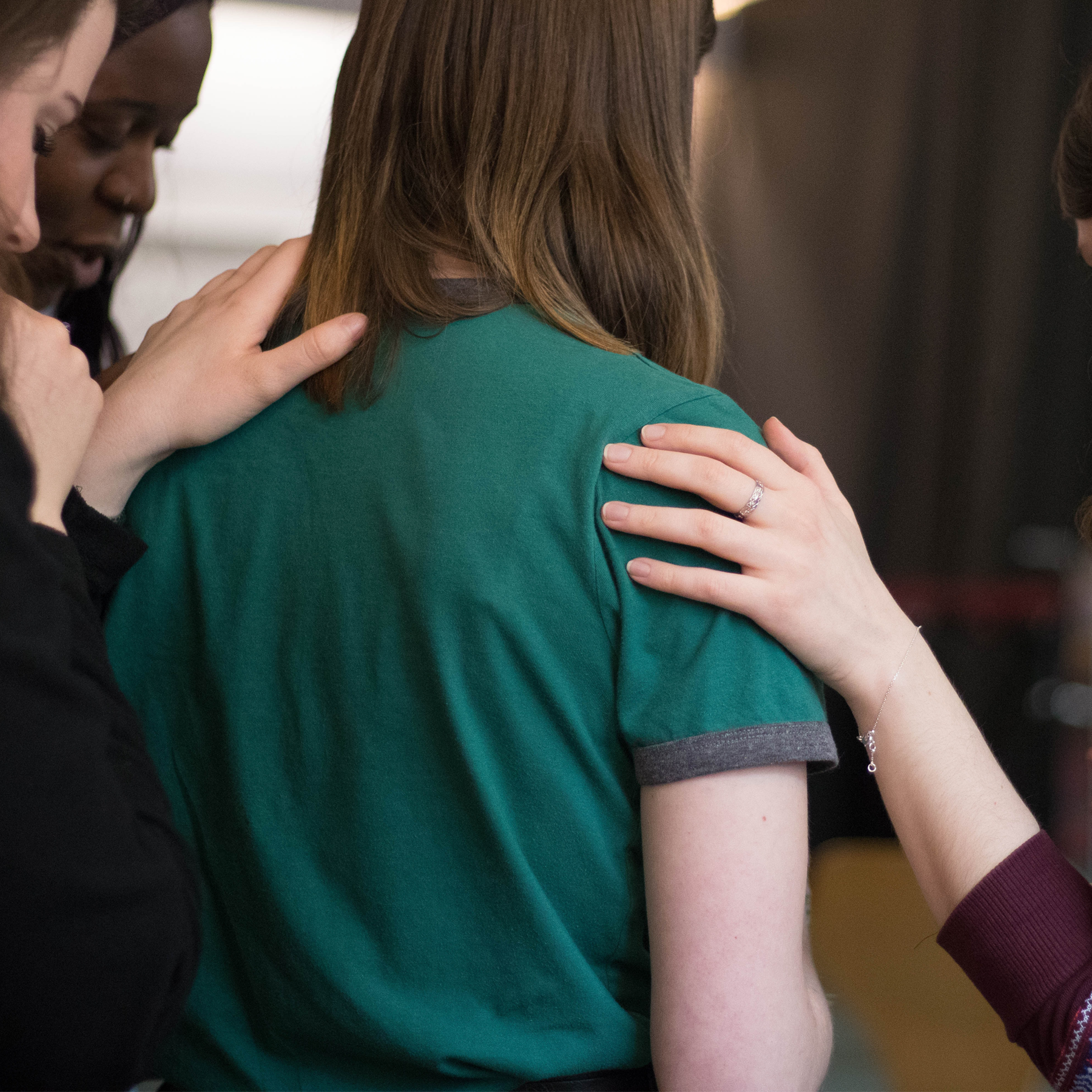 Two people comforting a sad person.