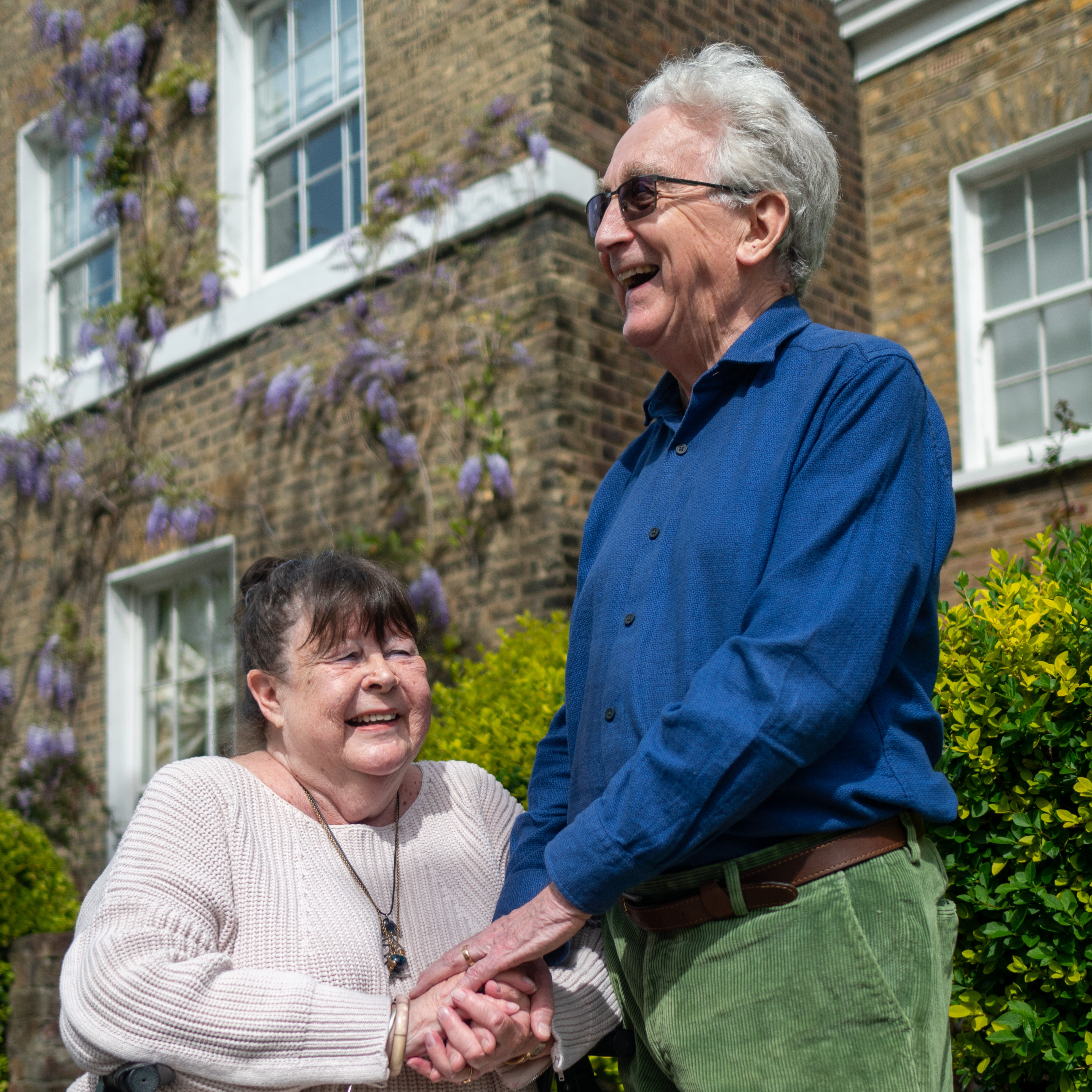 Two elderly individuals laughing.